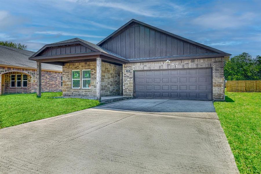 View of front facade featuring a front lawn and a garage