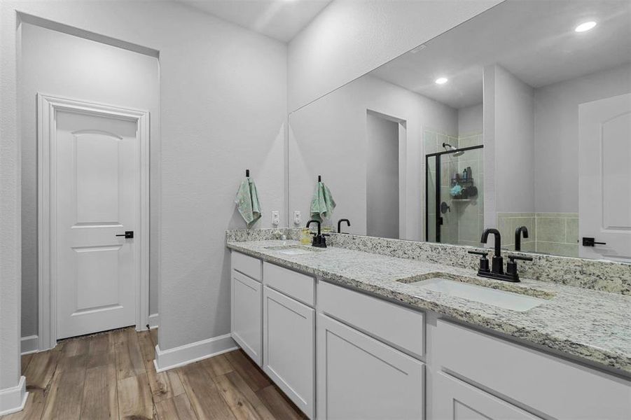 Bathroom featuring a shower with door, wood-type flooring, and vanity