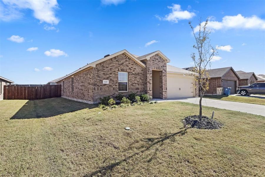 Ranch-style home featuring a garage and a front yard