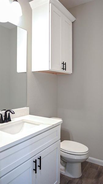 Bathroom featuring vanity, wood-type flooring, and toilet