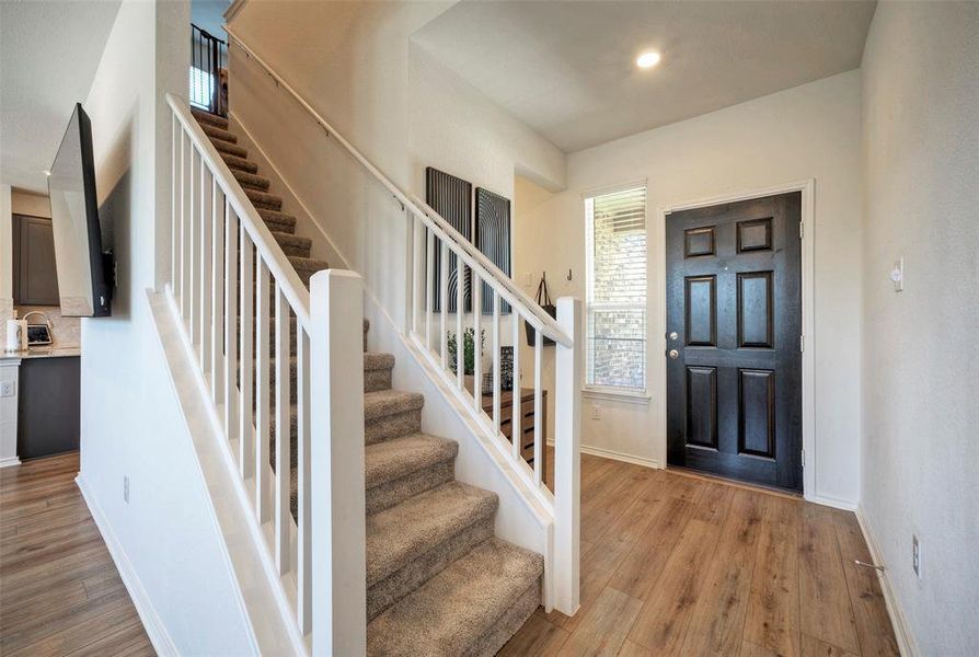 Beautiful front door with Laminate flooring in a light tan color. and Stairs to the upstairs