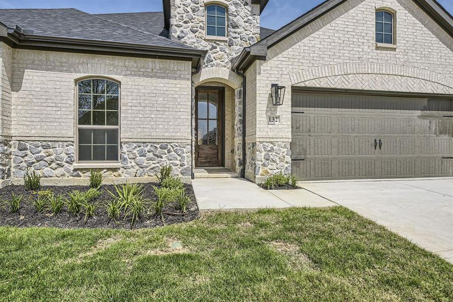 View of front of home with a garage and a front lawn