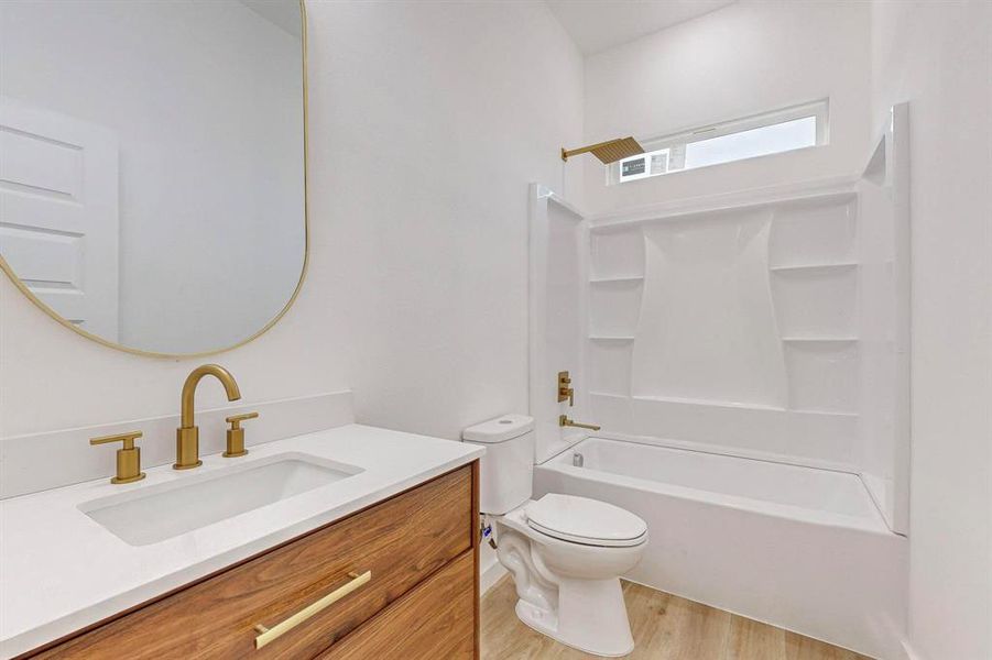 Full bathroom featuring bathtub / shower combination, hardwood / wood-style floors, vanity, and toilet