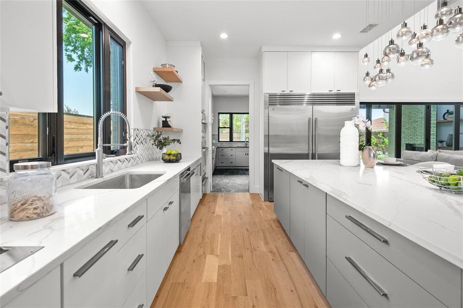 Kitchen featuring a healthy amount of sunlight, light hardwood / wood-style floors, and sink