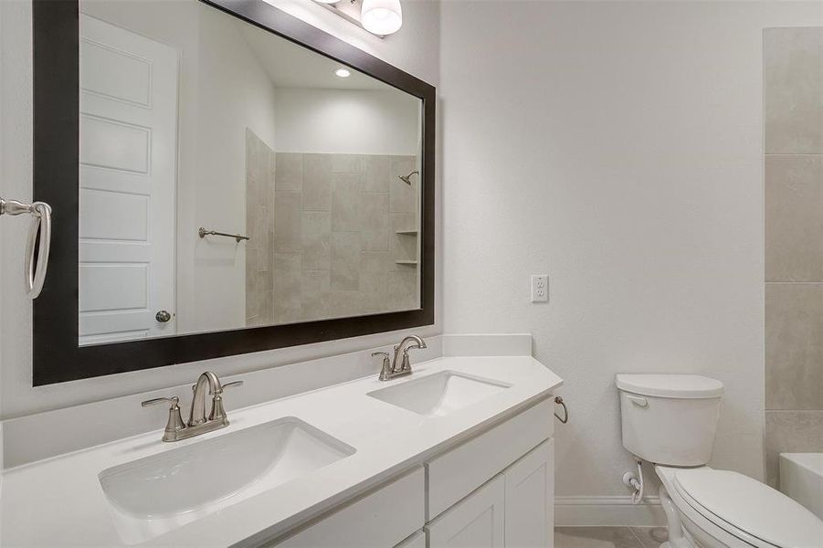 Bathroom featuring double vanity and toilet