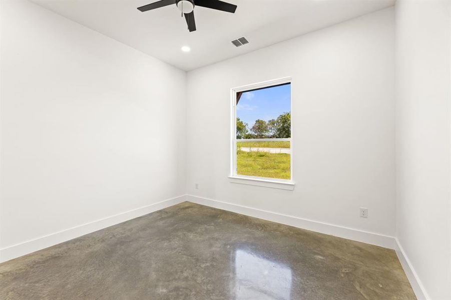 Unfurnished room with ceiling fan and concrete flooring