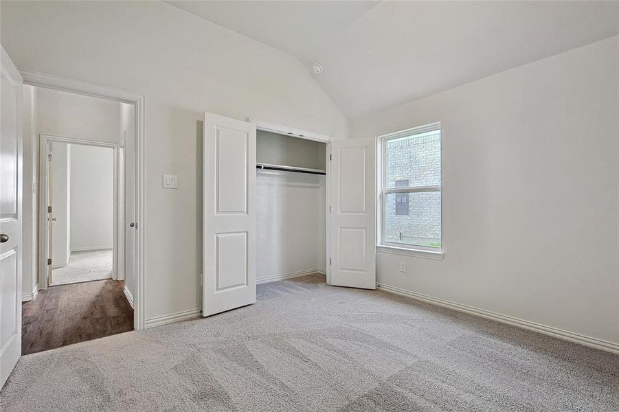 Unfurnished bedroom featuring a closet, vaulted ceiling, and hardwood / wood-style floors