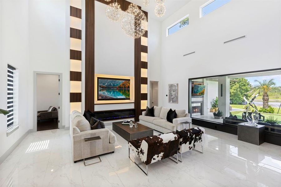 The great room highlights an elegant accent wall with lighted floating shelves that flank the gas fireplace.