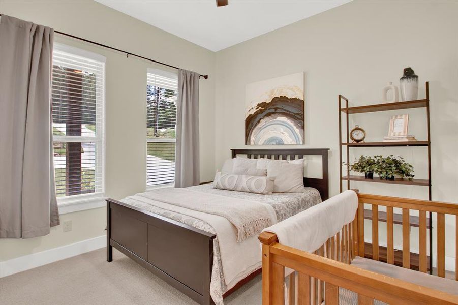 A second cozy, well-lit bedroom, identical in size, adorned with elegant curtains and a front view. The room has a calm and neutral color scheme, enhancing its serene ambiance.