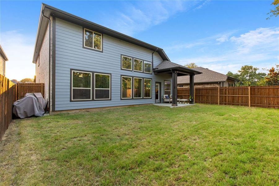 Rear view of property featuring a yard and a patio