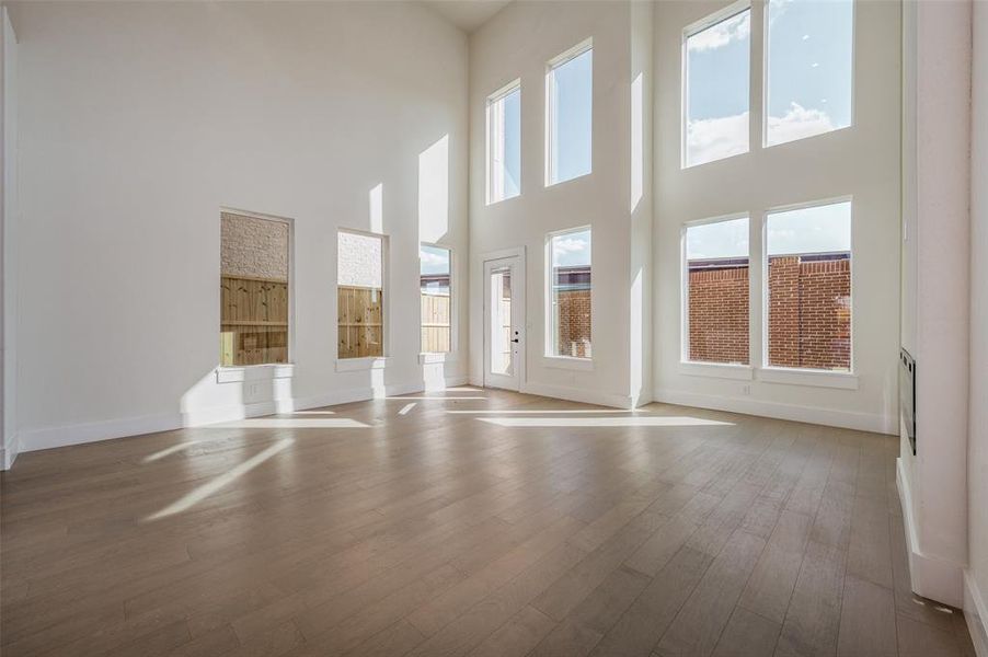 Spare room featuring light hardwood / wood-style flooring and a high ceiling