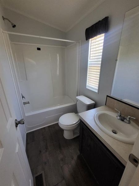 Full bathroom featuring vanity, toilet, hardwood / wood-style floors, and bathtub / shower combination