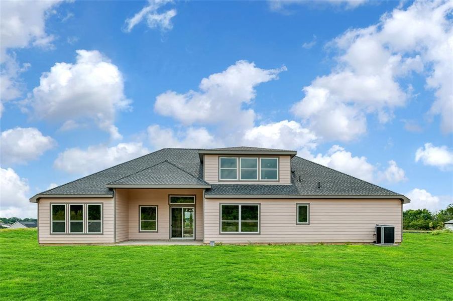 Rear view of house featuring central AC unit and a yard