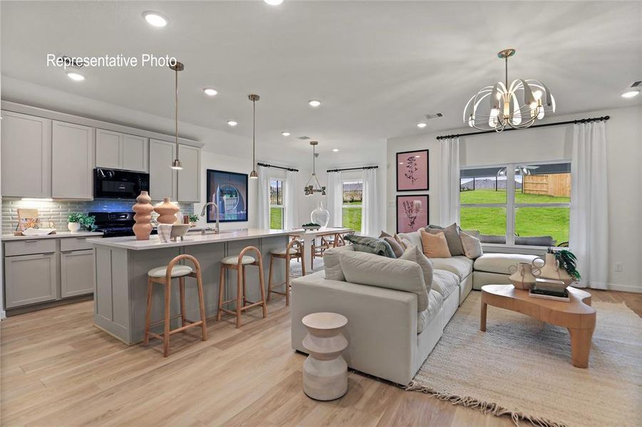 Living room featuring light hardwood / wood-style floors, a notable chandelier, and sink