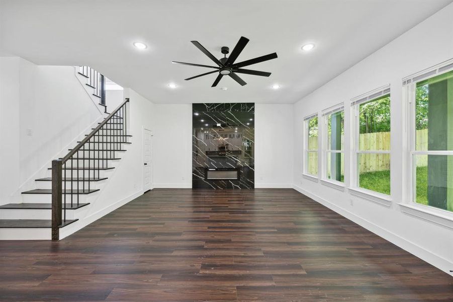 Unfurnished living room with dark hardwood / wood-style flooring and ceiling fan