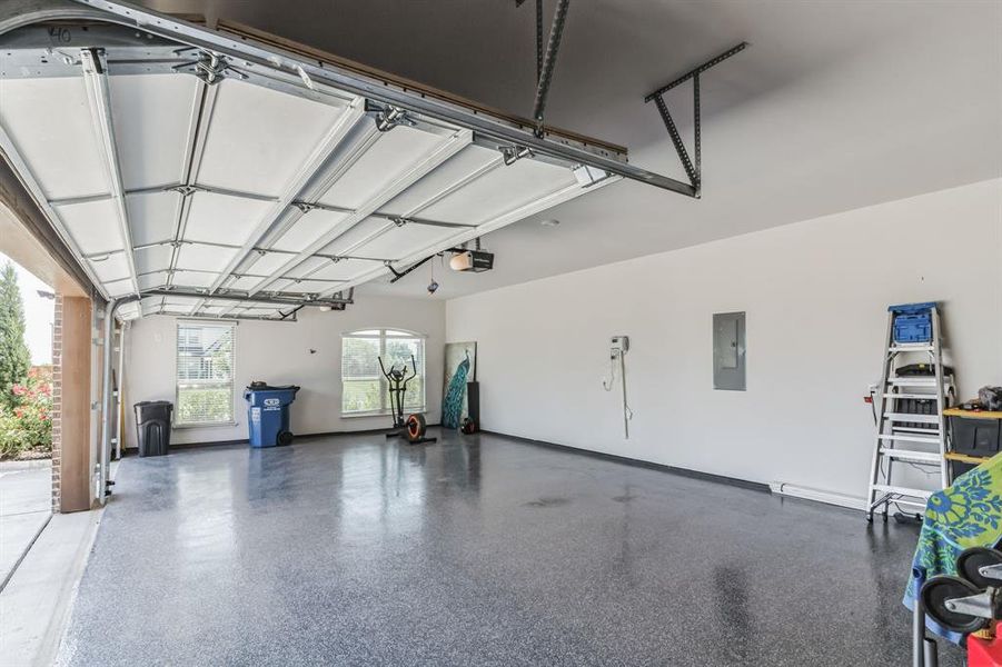 Garage featuring electric panel and a garage door opener