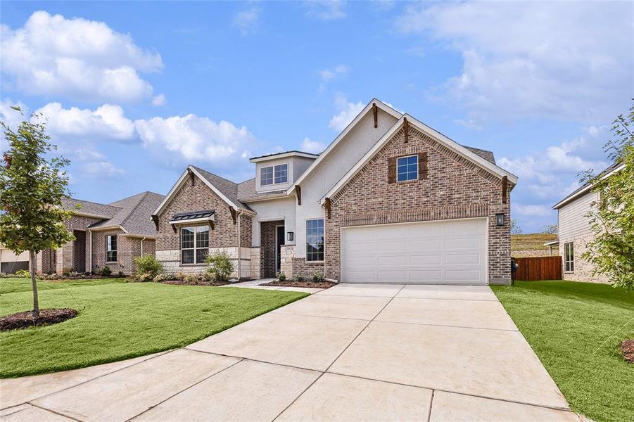 View of front facade featuring a garage and a front lawn