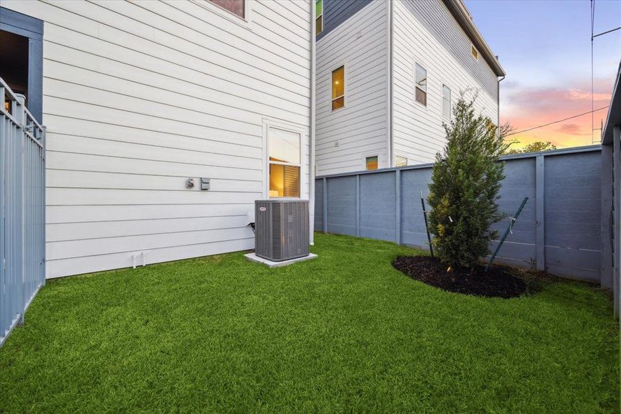 This private side yard offers a convenient green space, perfect for outdoor relaxation or small pet-friendly activities. Enclosed by a modern fence, it provides both privacy and low-maintenance upkeep.