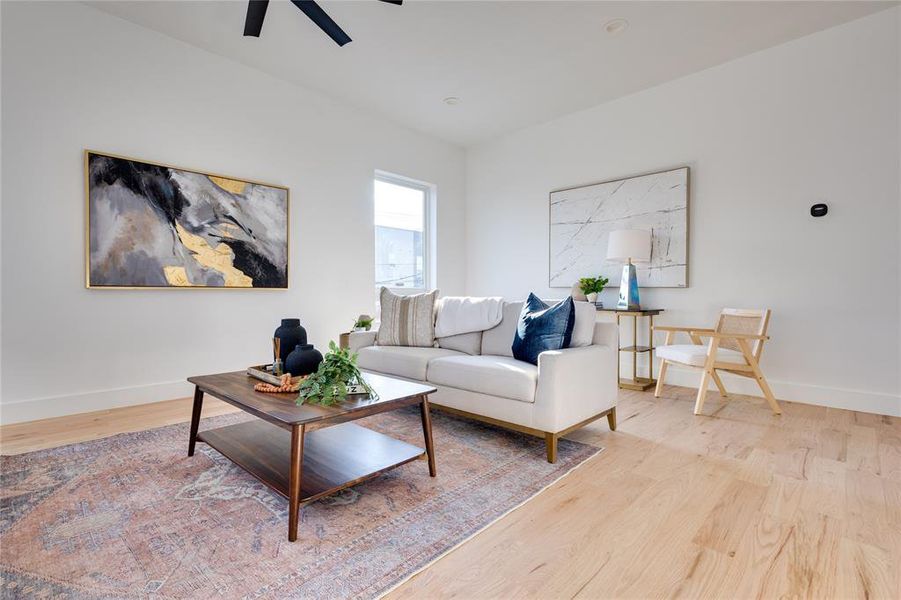 Living room with ceiling fan and light hardwood / wood-style flooring