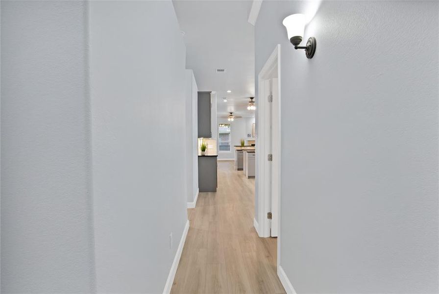 Front corridor hallway leading into the open concept living area with high ceilings and an abundance of natural light.