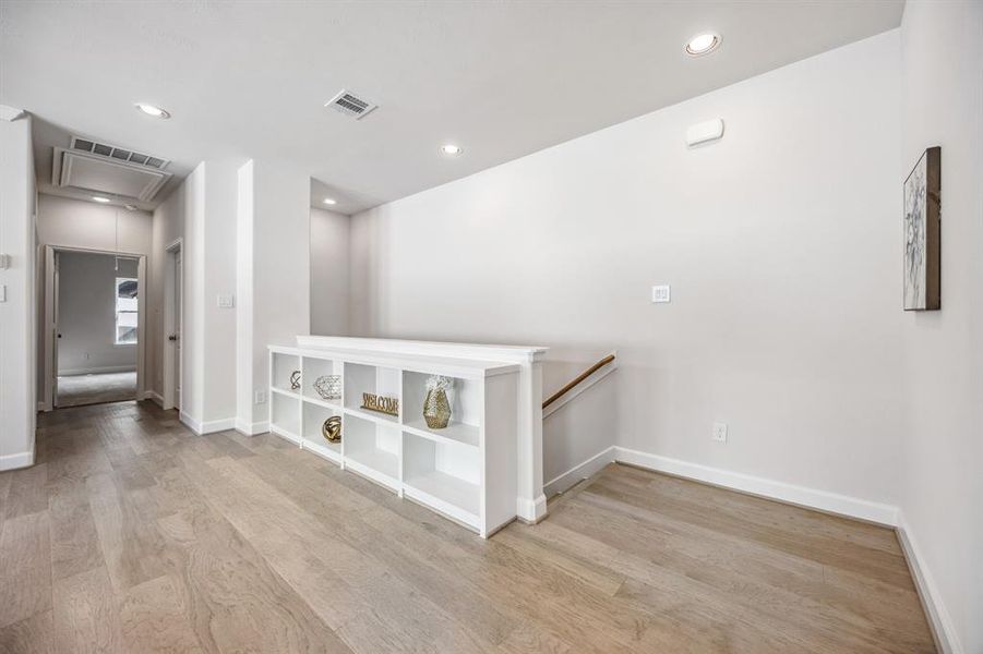 The upstairs game room, a stylish and versatile canvas awaiting your personal touch—with shelving that speaks of urban sophistication.