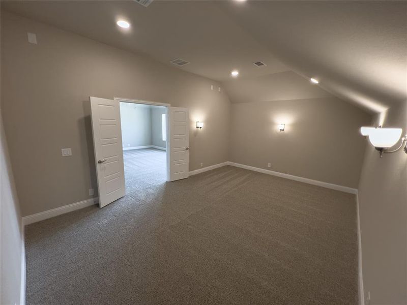 Bonus room with lofted ceiling and carpet