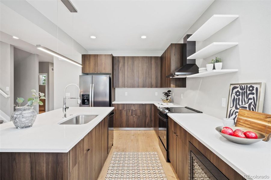 Spacious Kitchen with Plenty of Porcelanosa Cabinetry, Quartz Countertop Space and Fun Floating Shelves.