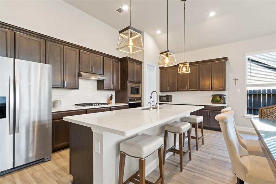 Modern kitchen featuring elegant pendant lighting and a stylish breakfast bar.