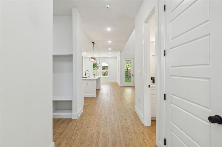 Corridor featuring sink and light hardwood / wood-style flooring