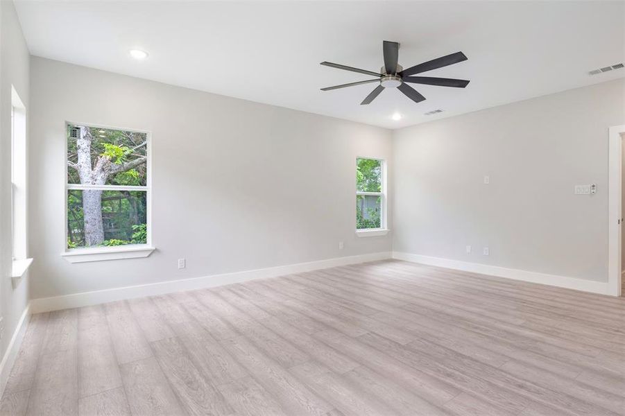 Empty room featuring light wood-type flooring and ceiling fan