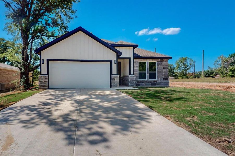 View of front of house featuring a garage and a front yard