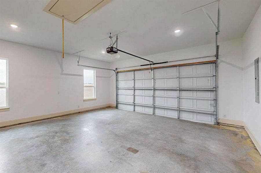 Garage featuring electric panel and a garage door opener