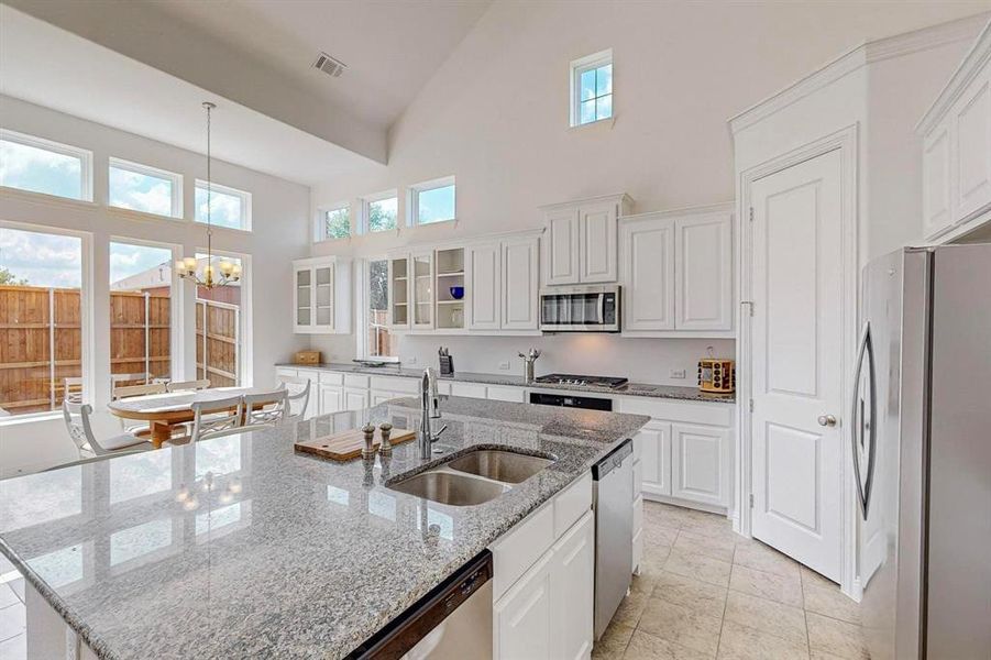 Another view of the kitchen showcasing the breakfast nook and plenty of natural light. With DUAL dishwashers and wall to wall cabinetry, this kitchen is a chefs dream and was made for entertaining!