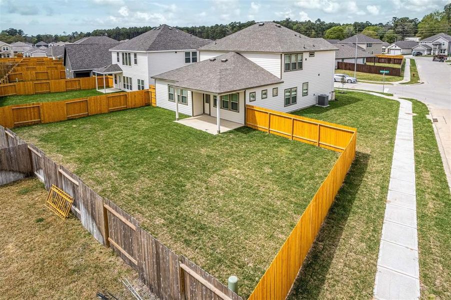 An aerial view showcases the full expanse of the backyard, illustrating its ample size and the potential for customization. The clear boundaries provided by the fencing ensure privacy, making it an ideal setting for play, relaxation, or entertaining. Photos are from another Rylan floor plan.
