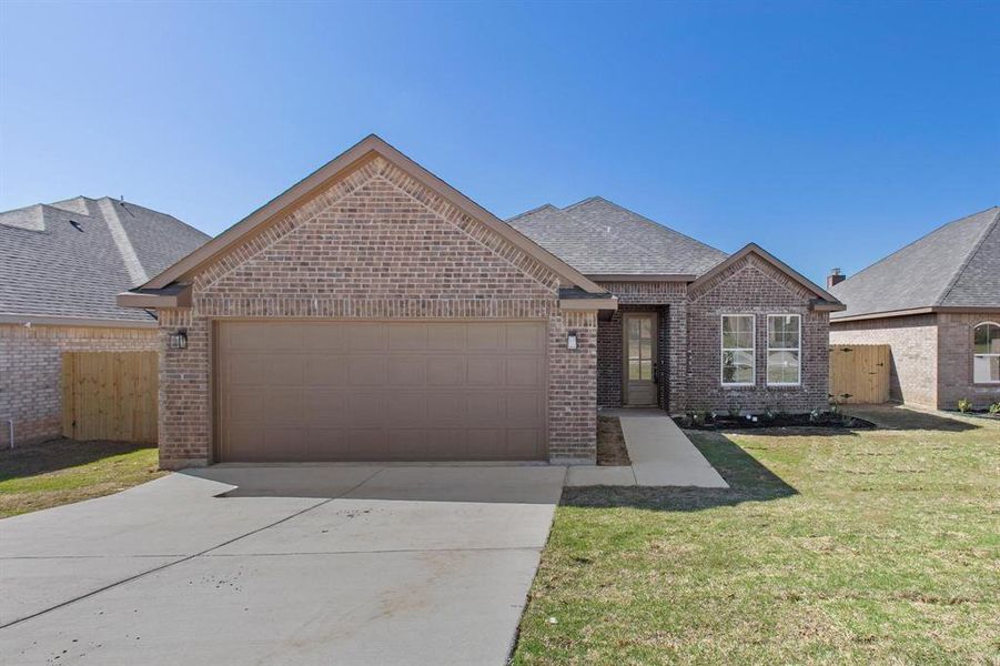 View of front facade featuring a front lawn and a garage