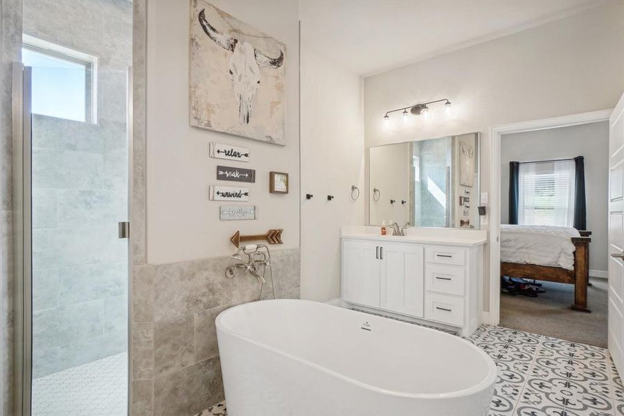 Bathroom with tile walls, vanity, separate shower and tub, and tile patterned floors