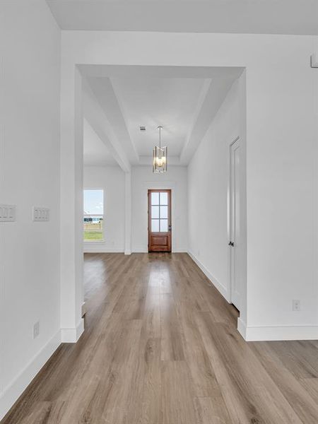 Foyer with an inviting chandelier and light hardwood / wood-style flooring