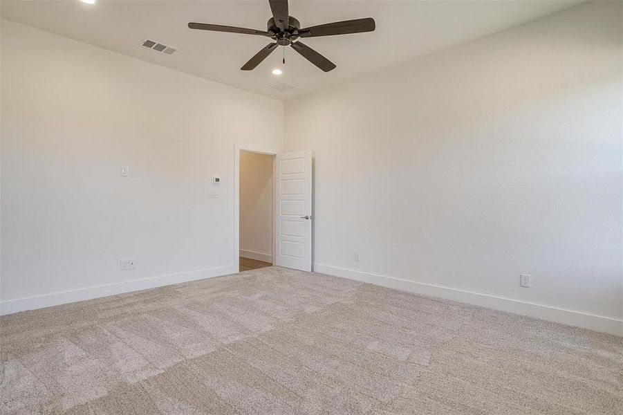 Unfurnished room featuring light colored carpet and ceiling fan