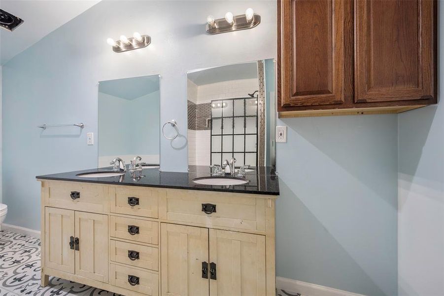 Bathroom featuring toilet, vanity, lofted ceiling, and a tile shower