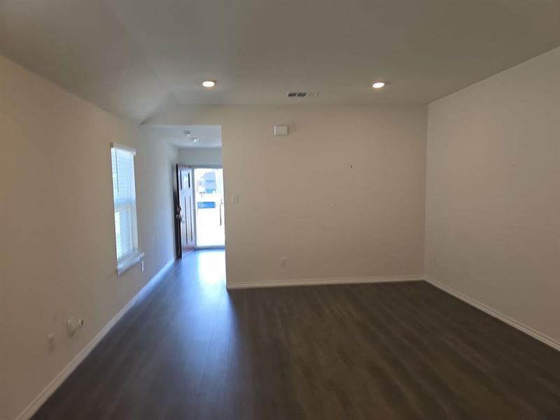 Spare room with vaulted ceiling and dark hardwood / wood-style flooring