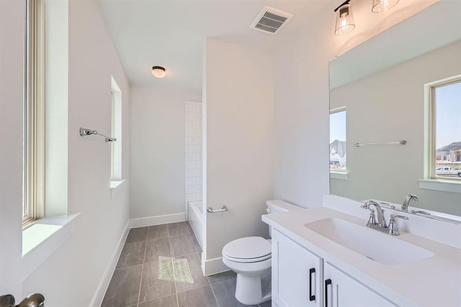 Full bathroom featuring shower / tub combination, vanity, tile patterned flooring, and toilet