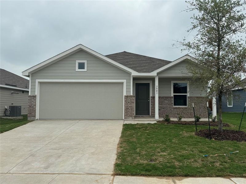 View of front of home with a garage, central AC, and a front lawn