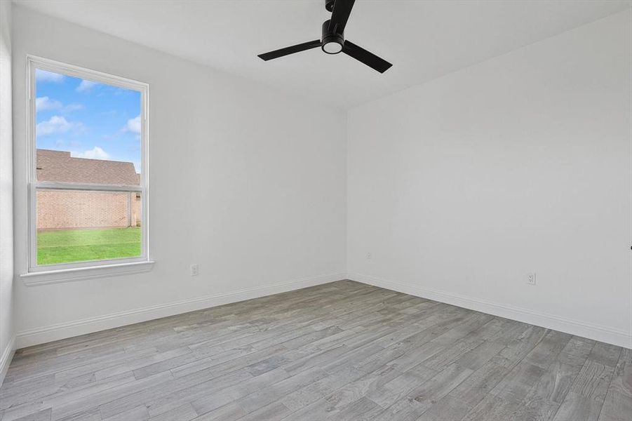 Spare room featuring ceiling fan and light wood-type flooring