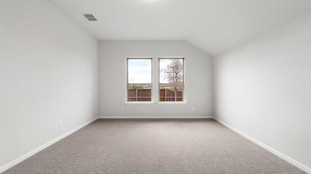 Spare room with vaulted ceiling and carpet floors