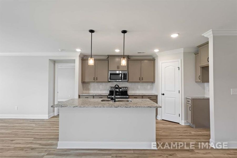 Kitchen with a center island with sink, light hardwood / wood-style flooring, sink, and appliances with stainless steel finishes