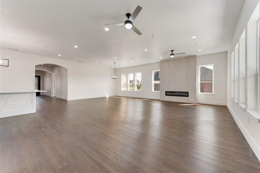 Unfurnished living room with a fireplace, ceiling fan, and dark hardwood / wood-style floors