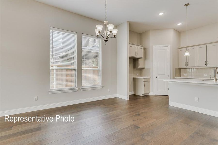 Unfurnished living room with sink, an inviting chandelier, and dark hardwood / wood-style floors