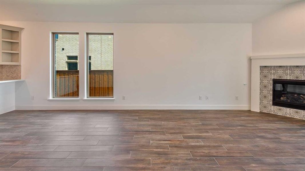 Unfurnished living room featuring a fireplace and built in shelves