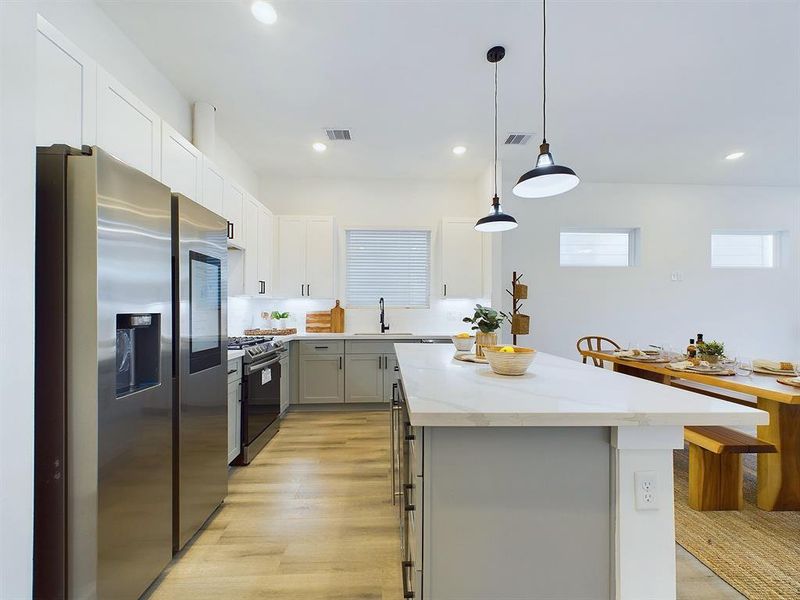 The kitchen offers  quartz countertops, stainless steel appliances, recessed lighting, and shaker cabinets and hardware with under cabinet lighting.