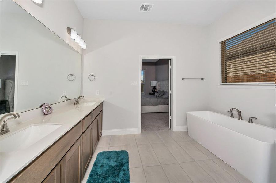 Bathroom with vanity, a bath, and tile patterned floors